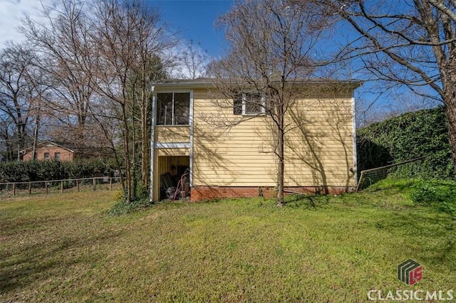 exterior space with a lawn and fence