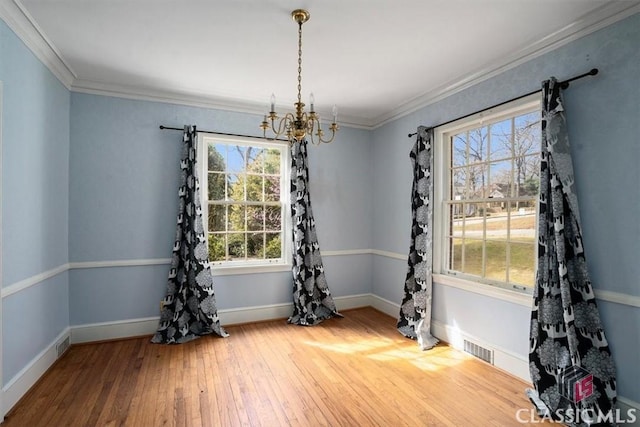 unfurnished dining area with visible vents, ornamental molding, baseboards, and hardwood / wood-style flooring