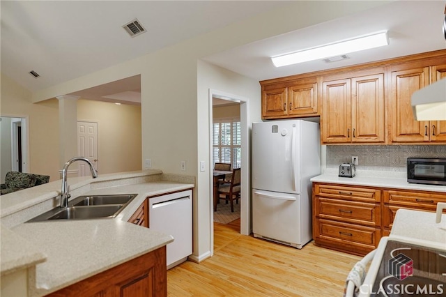 kitchen with white appliances, visible vents, light wood finished floors, a sink, and light countertops