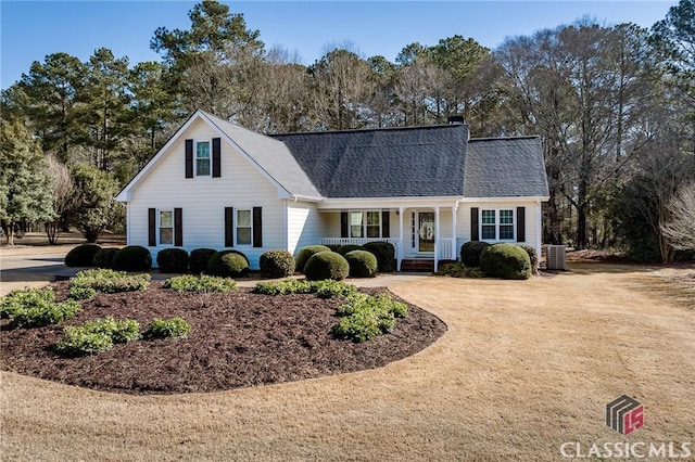 view of front of property featuring cooling unit, driveway, a porch, a shingled roof, and a chimney