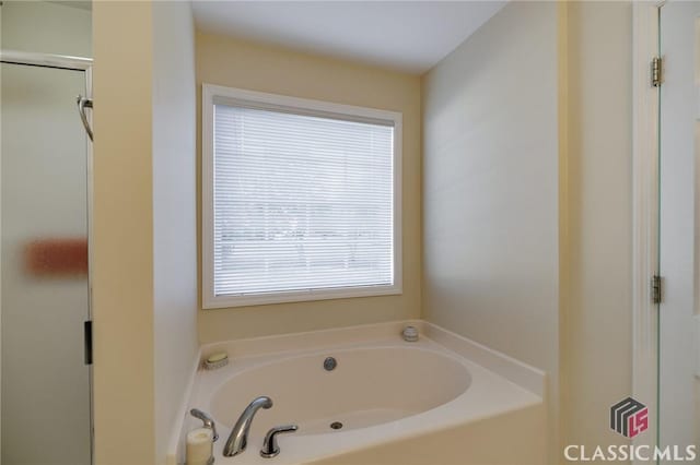 full bathroom with a shower with shower door and a garden tub