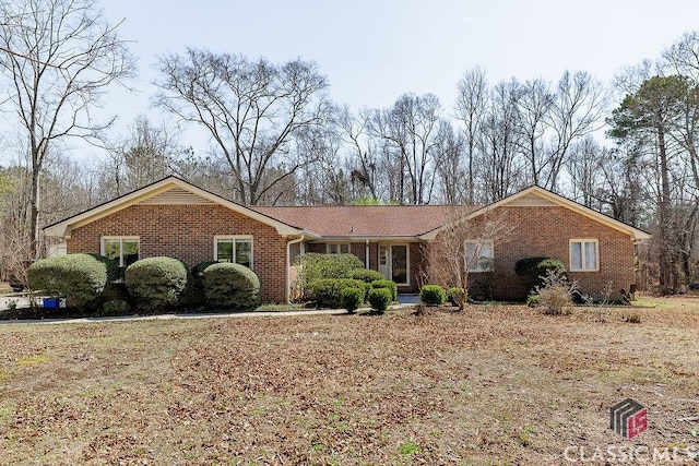 single story home featuring brick siding