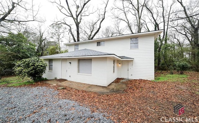 back of property featuring gravel driveway