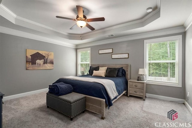 carpeted bedroom featuring a raised ceiling, baseboards, visible vents, and ornamental molding