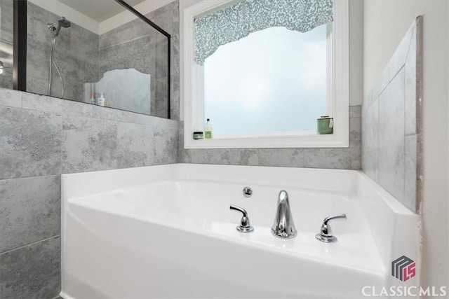 bathroom with a bath and a stall shower
