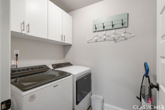 laundry room with cabinet space, separate washer and dryer, and baseboards