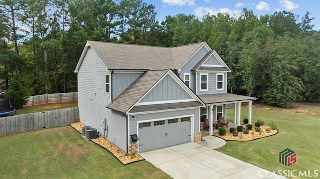 craftsman-style house featuring fence, a shingled roof, a front lawn, concrete driveway, and board and batten siding