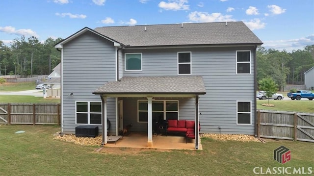 rear view of house with a fenced backyard, a lawn, a patio, and roof with shingles