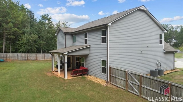 back of house with fence, central air condition unit, roof with shingles, a lawn, and a patio