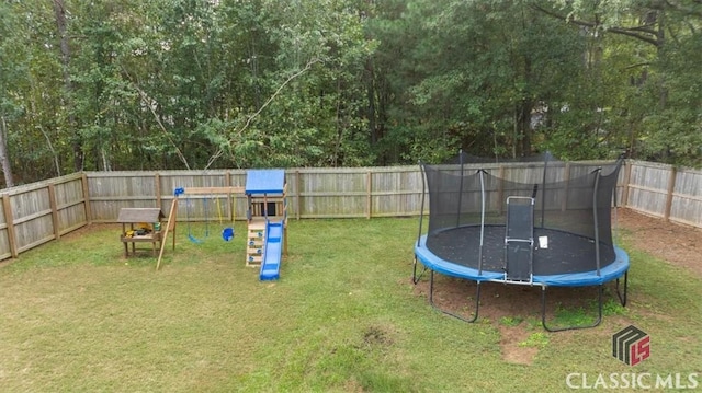 view of yard with a trampoline and a fenced backyard