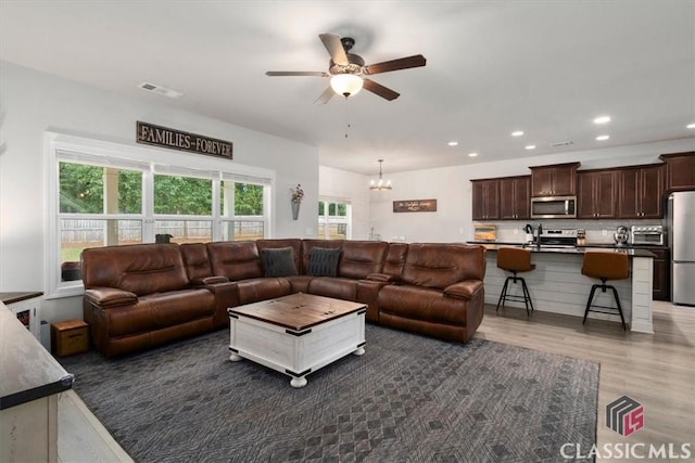living area featuring visible vents, ceiling fan with notable chandelier, wood finished floors, recessed lighting, and a toaster