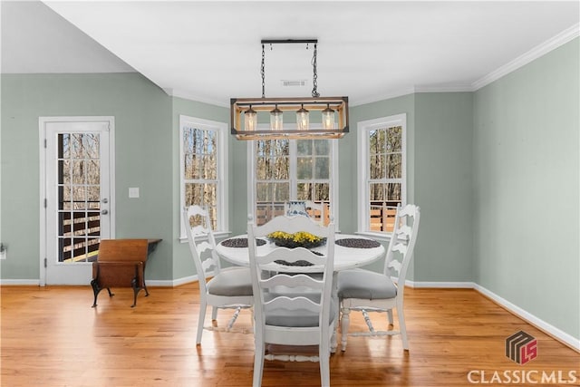 dining room featuring visible vents, baseboards, wood finished floors, and ornamental molding