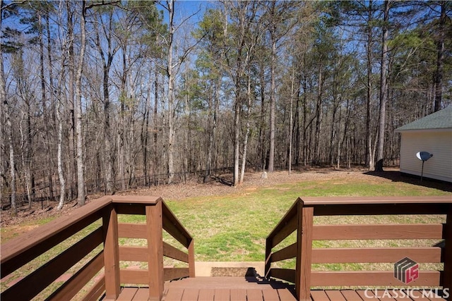 wooden deck with a yard and a forest view