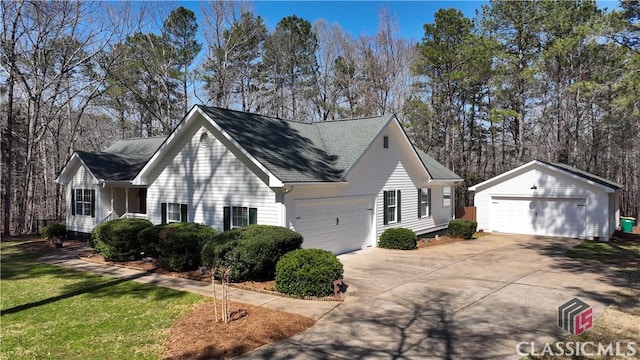 view of side of property featuring a yard, an outbuilding, and a shingled roof