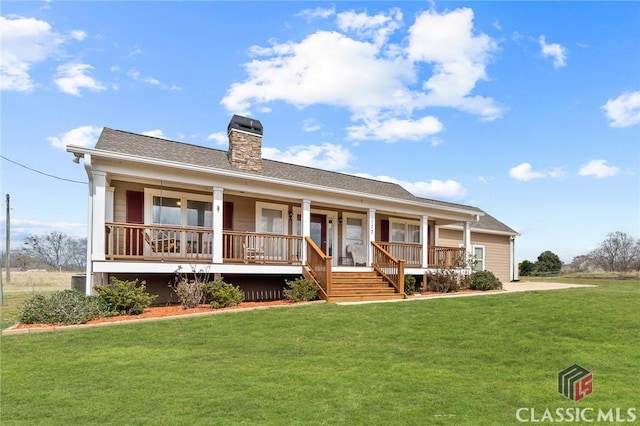 view of front of house featuring covered porch, a chimney, and a front yard