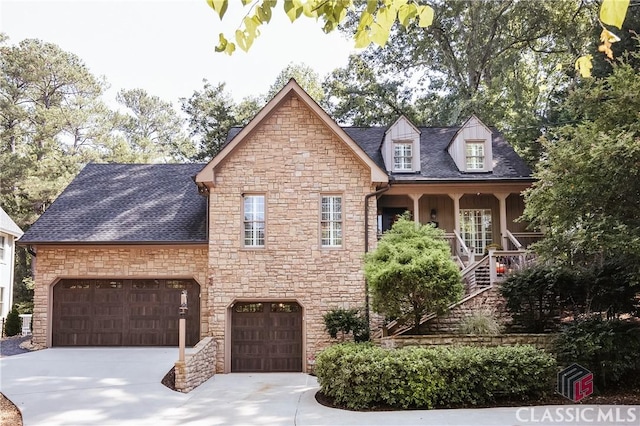 view of front of home featuring stone siding, concrete driveway, and a shingled roof