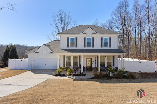 traditional-style home featuring fence, a porch, concrete driveway, a garage, and a gate