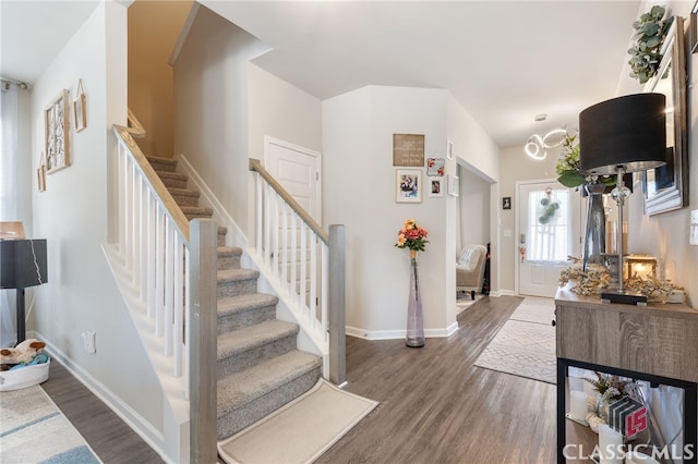 entrance foyer featuring stairs, baseboards, and wood finished floors