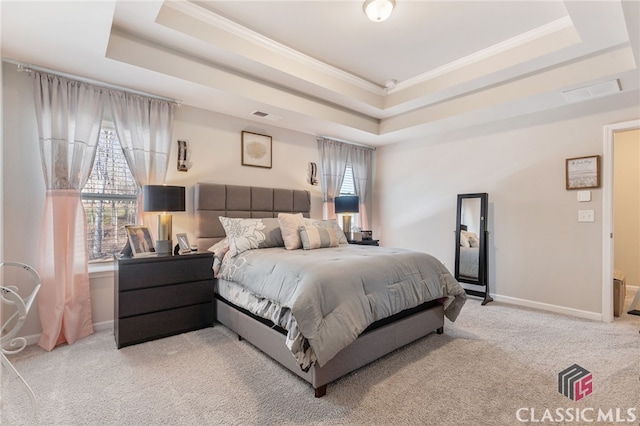 bedroom featuring visible vents, a raised ceiling, and multiple windows