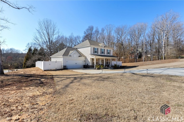 view of front facade with a gate, fence, covered porch, concrete driveway, and a garage