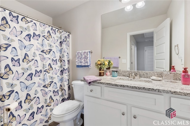 bathroom featuring a shower with shower curtain, toilet, and vanity