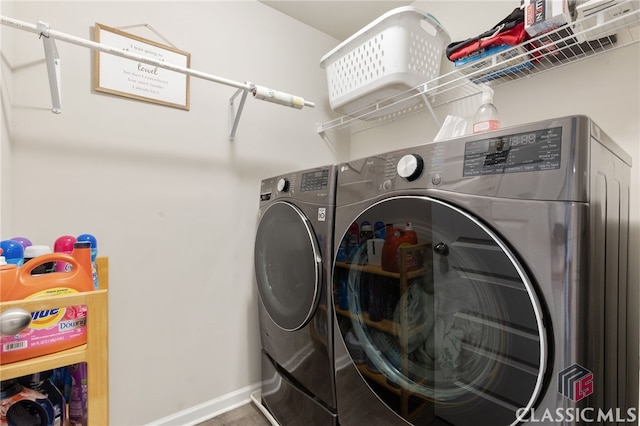 laundry room with baseboards, laundry area, and washer and clothes dryer