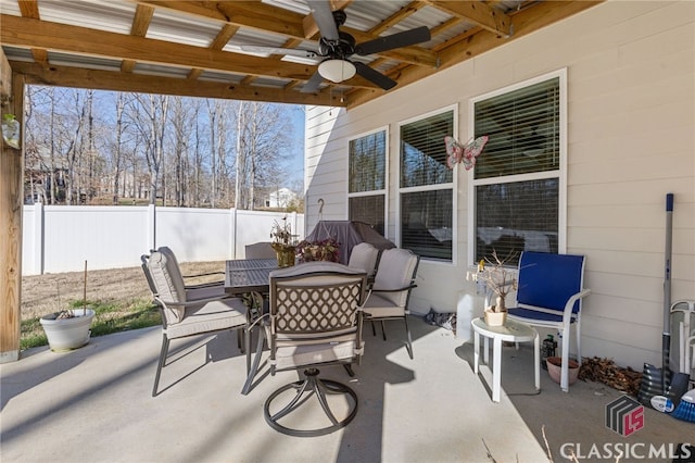 view of patio featuring outdoor dining space, a ceiling fan, and fence