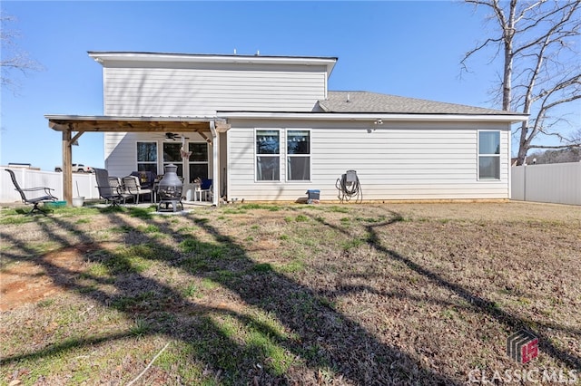 rear view of property featuring a patio, a yard, and fence