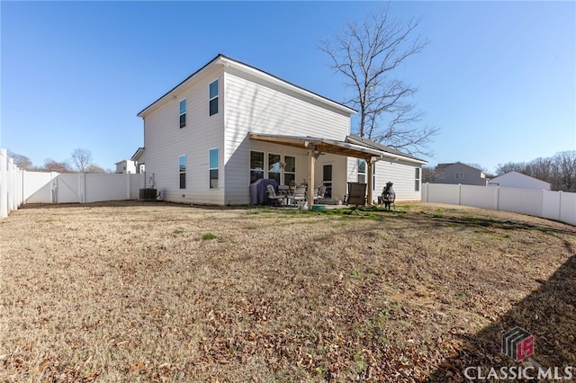 rear view of property featuring a yard, central AC unit, a fenced backyard, and a patio area