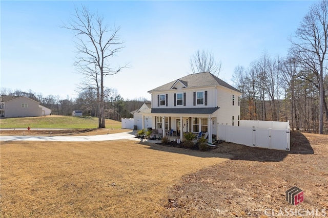 view of front of house featuring fence, roof with shingles, a porch, concrete driveway, and a front lawn