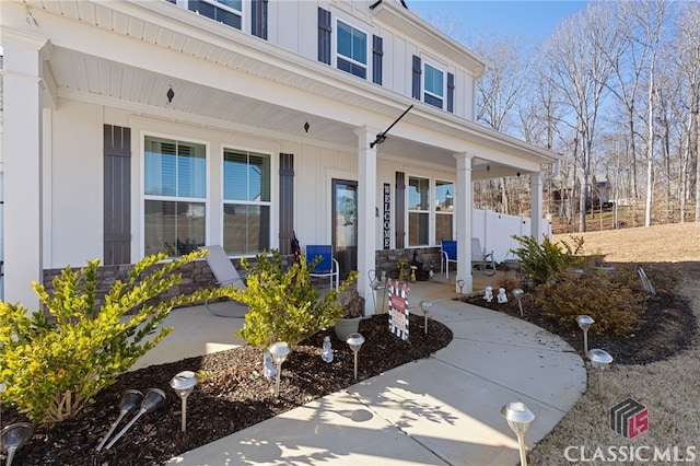 doorway to property featuring board and batten siding and covered porch