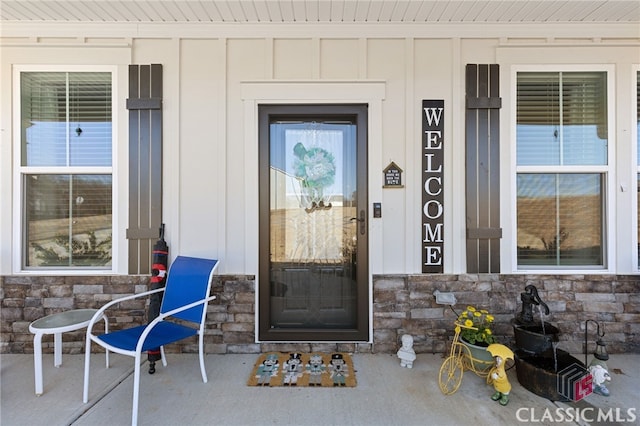 entrance to property featuring board and batten siding and stone siding