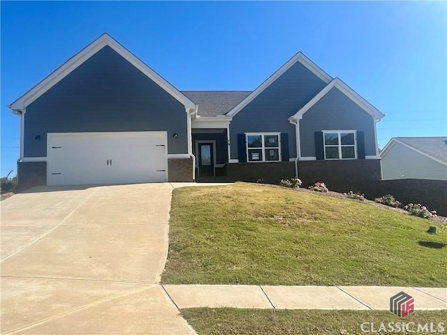 view of front of property featuring a front yard, concrete driveway, and a garage