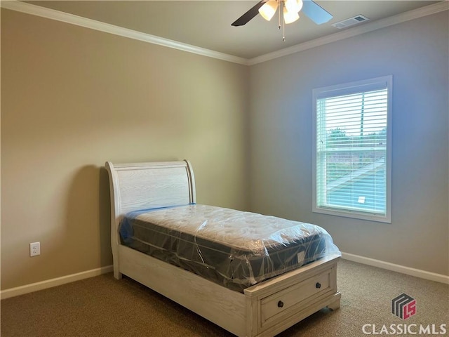 carpeted bedroom featuring ceiling fan, visible vents, baseboards, and ornamental molding