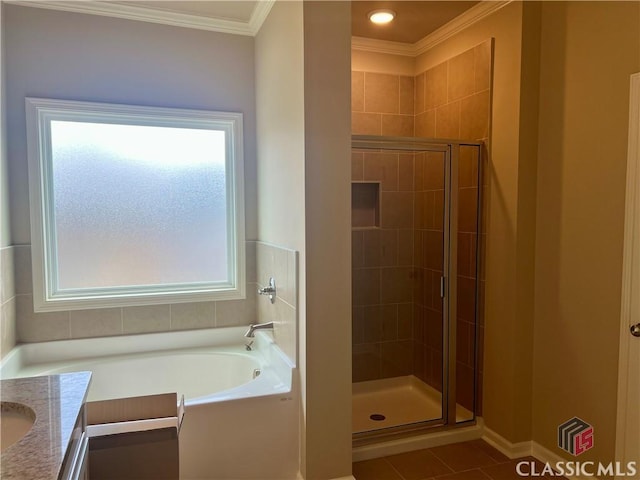 full bathroom featuring a shower stall, vanity, crown molding, and a garden tub