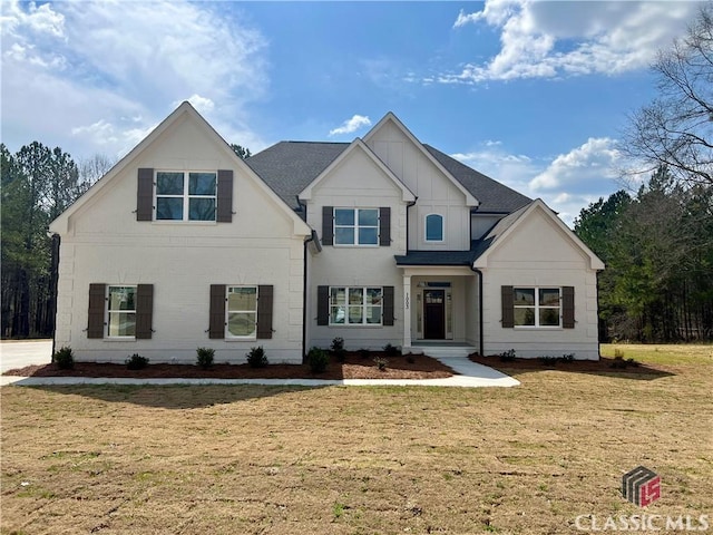 view of front of property with a front yard and a shingled roof