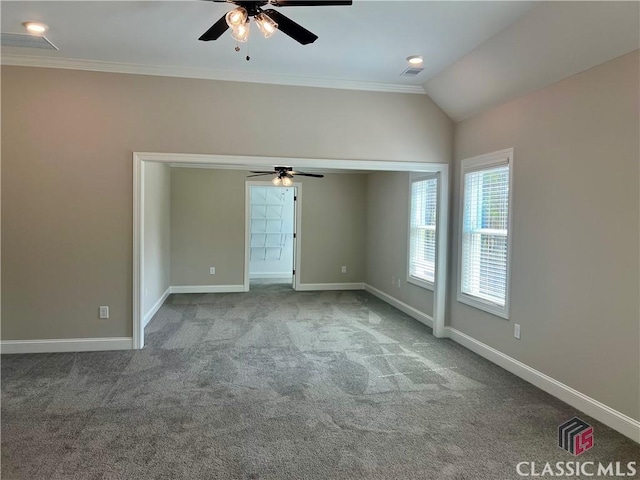 carpeted empty room with crown molding, a ceiling fan, baseboards, and vaulted ceiling