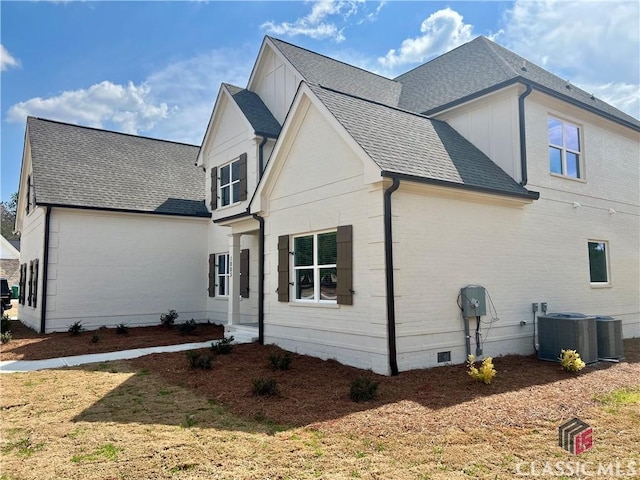 view of home's exterior with crawl space, central AC unit, and roof with shingles