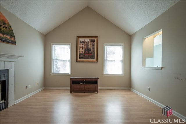 interior space with a wealth of natural light, a fireplace, and light wood-type flooring