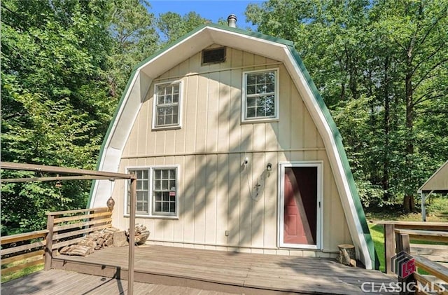 view of home's exterior with a wooden deck and a gambrel roof