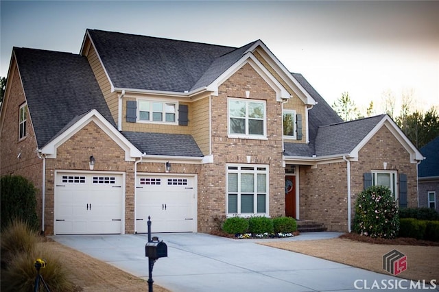 view of front facade with an attached garage, driveway, and a shingled roof