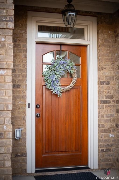 entrance to property featuring brick siding