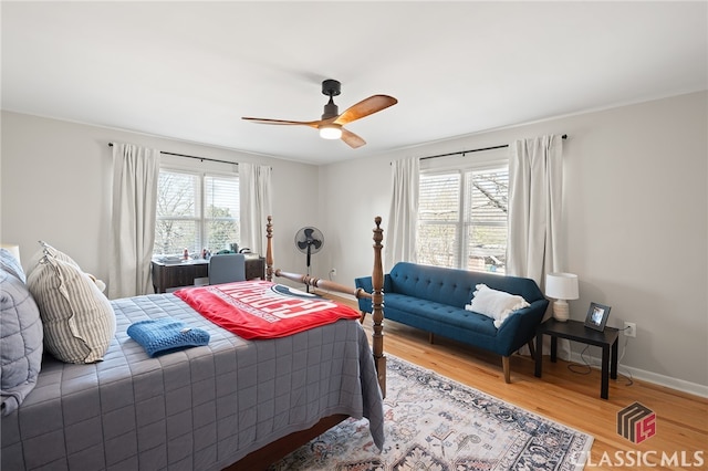 bedroom featuring baseboards, light wood-style floors, and ceiling fan