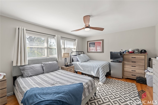 bedroom with refrigerator, a ceiling fan, and light wood finished floors