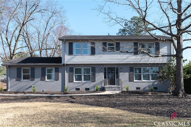 colonial-style house with crawl space, brick siding, and a front yard