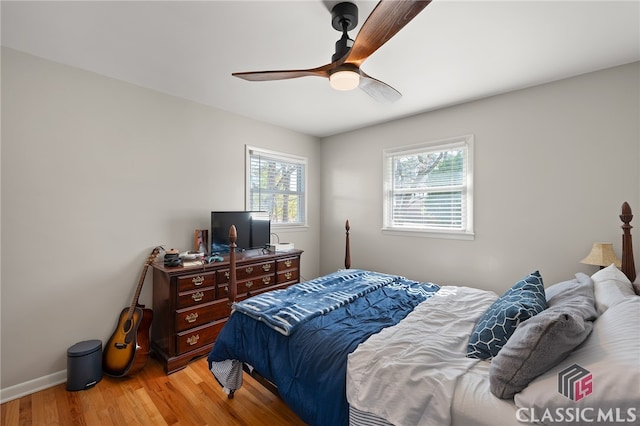 bedroom with baseboards, light wood-type flooring, and ceiling fan