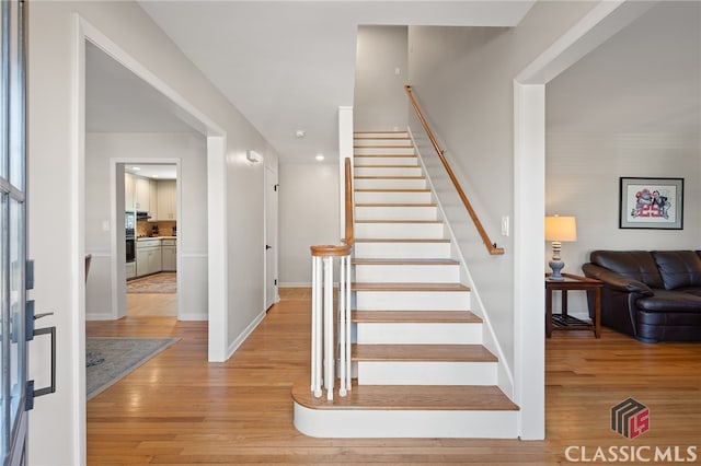 stairs featuring wood finished floors and baseboards