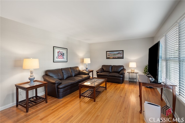 living area with baseboards and light wood-type flooring