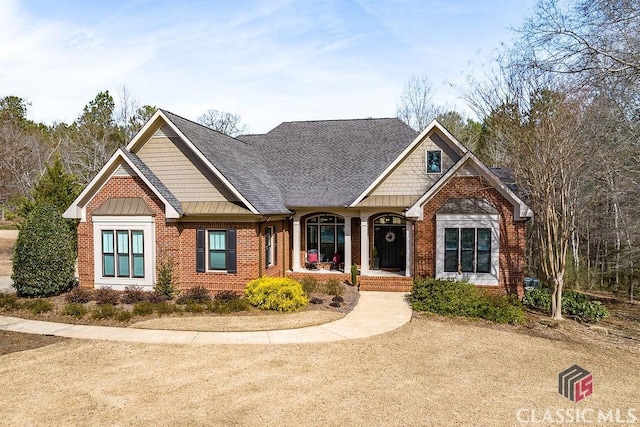 craftsman-style house featuring brick siding and roof with shingles