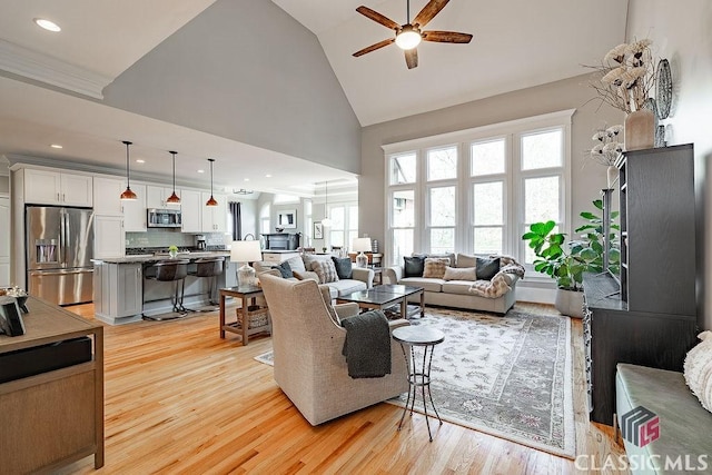 living room with recessed lighting, high vaulted ceiling, a ceiling fan, and light wood finished floors